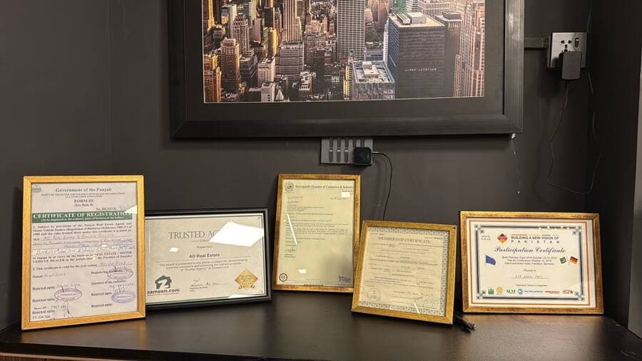 Framed certificates and awards displayed at the AD Real Estate office in DHA Phase 5, Islamabad